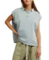 Remera estilo polo celeste, de corte amplio con cuello clásico y botonadura corta en el frente. Tiene mangas cortas con dobladillo y aberturas laterales en el ruedo.