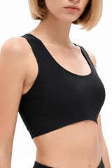 Soutien deportivo negro con escote redondo y tirantes anchos, diseñado para brindar soporte y comodidad.