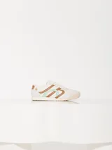 Zapatilla urbana acordonada de cuero vacuno color blanco, combinada con cuero vacuno descarne. Tiene el logo JCH en los laterales y apliques Lipstick y Ladybug.