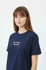 Remera negra de algodón con cuello redondo, manga corta y estampa frontal con texto en blanco.