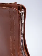 Bota de media caña color negro, con cierre frontal y suela de goma con plataforma.