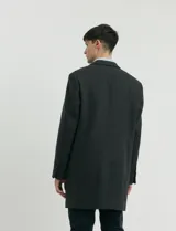 Sobretodo 3/4 de paño, color gris oscuro, con cuello solapa, cierre frontal de botones, manga larga y bolsillos laterales de ribete.