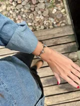 Pulsera de alpaca con diseño de eslabones y tres cruces engarzadas, con ajuste a presión.