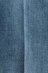 Pantalón de jean de tiro alto con corte wide leg, confeccionado en denim de algodón rígido. Presenta cierre frontal con doble botón, pasacintos y pliegues marcados en la parte delantera y trasera.