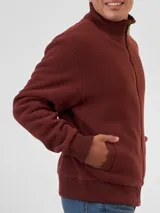 Campera de polar color bordó con cierre frontal completo, cuello alto tejido y puños y ruedo acanalados. Cuenta con bolsillos laterales.