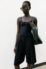 Bermuda de tiro medio color negro, con cintura elástica y detalle de pliegues delanteros.