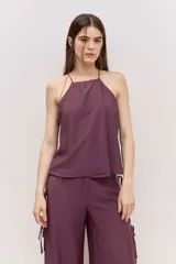 Blusa bordó de tiras finas con cuello halter y caída suave.