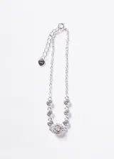 Pulsera de plata 925 con cadena forcé y zirconias blancas incrustadas, destacando un dije central rodeado de zirconias pequeñas. Incluye cadena de extensión con pequeño dije en forma de corazón.