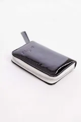 Billetera negra de cuero vacuno con cierre metálico. Cuenta con múltiples compartimentos para tarjetas y billetes.