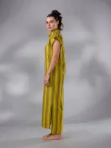Vestido largo de lino y algodón con diseño de rayas verticales en tonos mostaza y verde. Presenta escote en V, cuello solapa ancho, mangas cortas con diseño capa, corte recto y lazo ajustable en la cintura.