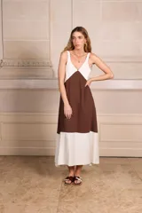 Vestido largo sin mangas, con escote en V y diseño de bloques de color. La parte superior es blanca, la sección media es color camel/marrón claro, y el ruedo inferior es blanco.