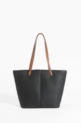 Cartera tipo tote de diseño minimalista en color negro con textura granulada, que presenta correas largas en color suela y detalles de remaches metálicos dorados en la unión con el cuerpo del bolso.
