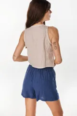 Top musculosa amarillo de lino italiano, con cuello redondo y cierre frontal de botones de nácar.