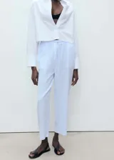 Pantalon de corte recto y tiro alto, confeccionado en tejido de lino y algodón con diseño de rayas verticales finas en tono celeste y blanco. Cuenta con cintura elástica con cordón ajustable.