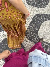 Vestido largo marrón de crepe texturizado, con cuello halter fruncido, diseño holgado y falda larga con vuelo.