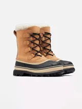 Bota de nieve Sorel modelo Caribou, con diseño impermeable de caña media. Presenta una parte superior de nubuck color tostado con cordones negros, base de goma vulcanizada negra y borde de pelo sintético en la parte superior.