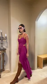 Vestido midi color uva con escote corazón, tirantes finos y aberturas laterales en la cintura. Presenta un diseño con frunces frontales y una falda con tajo lateral.