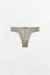 Braguita de tiro medio con estampado de rayas verticales en blanco y negro, confeccionada en viscosa 100%. Presenta cintura elástica y acabados en ondas.