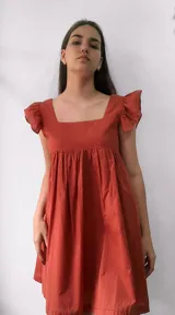 Vestido corto color terracota, con escote cuadrado, mangas cortas con volados y falda fruncida.