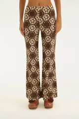 Pantalón acampanado marrón con estampado floral y geométrico, de tiro medio y calce ajustado en la parte superior.