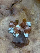 Aros colgantes con forma de hojas en color blanco y dorado, con base cuadrada dorada. Hechos a mano con plástico reciclado.