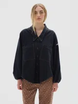 Camisa de denim oversized con cuello camisero, cierre frontal de botones, bolsillos frontales y mangas balloon con puños elásticos.