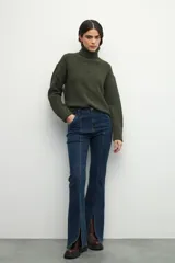 Polera de cuello alto con textura tramada, manga larga con puños acanalados y diseño holgado.