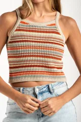 Top tejido de punto con diseño a rayas horizontales en tonos tierra, naranja y crema. Presenta un corte al cuerpo, escote halter y breteles finos.