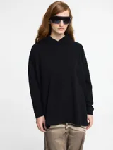 Sweater negro con capucha y tajos verticales laterales en la cintura.