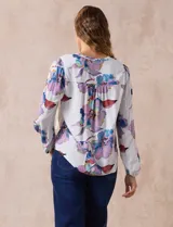 Blusa de gasa estampada con flores, marca Zac & Rachel. Tiene cuello a la base con abertura central con botones y mangas largas abullonadas.