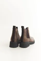 Botas Chelsea negras de cuero con elástico lateral, suela track y tirador trasero.