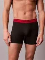 Pack de tres boxers largos Calvin Klein confeccionados en microfibra elástica. Presentan una cintura elástica con el logo de la marca en contraste, disponible en tres colores diferentes: negro con letras blancas, negro con letras negras y negro con letras rojas.