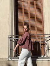 Blusa color chocolate de diseño holgado, con cuello redondo, frunce frontal y mangas abullonadas con puños ajustados.