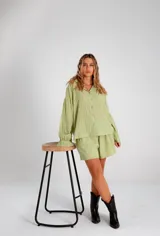 Conjunto compuesto por camisa oversize de manga larga con puños y short con cintura elástica. Ambas prendas presentan un diseño de rayas verticales tono sobre tono con textura suave y fluida.