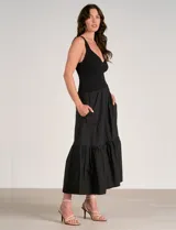 Vestido maxi combinado negro de la marca Elan, con torso de punto acanalado con escote en V pronunciado y breteles anchos. Cuenta con corte a la cintura y falda larga fluida con volumen, bolsillos laterales y volante fruncido en el ruedo.