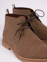 Botas tipo chukka color marrón, con cordones al tono, costuras reforzadas y suela de goma en color caramelo.
