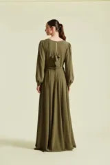 Vestido midi negro con escote en V profundo y botones dorados frontales. Presenta mangas largas abullonadas, corte en la cintura y falda fluida.