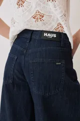 Jeans de denim azul oscuro con corte barrel y diseño amplio en las piernas.