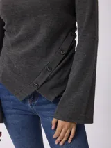 Remera de manga larga en tejido acanalado color gris oscuro, con diseño de corte asimétrico y cierre lateral con botones.