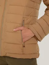 Campera acolchada color camel con capucha ajustable con cordón, cierre frontal con cremallera y dos bolsillos delanteros con cierre.