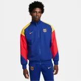Chaqueta deportiva Nike del F.C. Barcelona, con cierre frontal completo y cuello alto. Diseño color azul con bloques en rojo y amarillo en las mangas, e incluye el logo de Nike y el escudo del club bordados.
