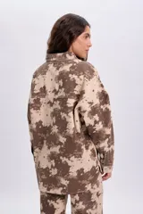 Sobrecamisa de corte oversize con estampado animal print abstracto en tonos marrón y beige, cierre frontal de botones metálicos y bolsillos appliqués en el pecho.
