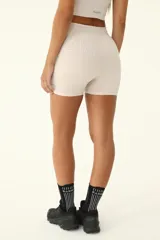 Short deportivo color beige, de tiro alto y corte ajustado. Cuenta con cintura elástica con cordón ajustable reflectivo.