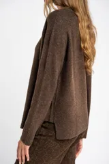 Sweater de tejido de punto color bordó, con cuello redondo, mangas largas y puños acanalados. Presenta un diseño de corte recto y textura suave.