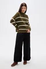 Sweater de punto con diseño de rayas horizontales blancas sobre fondo verde oliva, de corte holgado, cuello alto y mangas largas.