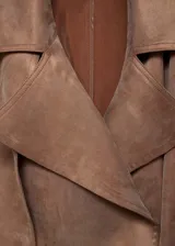 Abrigo marrón claro con cuello y puños de denim azul oscuro, corte clásico, largo hasta la rodilla y cinturón de lazo.