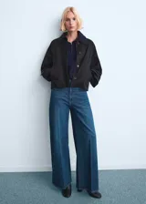 Jeans wide leg de tiro alto en color azul, con diseño largo, trabillas, cinco bolsillos y cierre delantero de cremallera y botón.