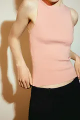 Top de punto color crema, sin mangas, con cuello redondo y corte ajustado.