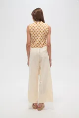 Pantalon de corte recto y tiro alto, confeccionado en viscosa de color natural, con cintura elástica y cordón ajustable.