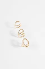 Set de tres anillos de metal plateado con diseño orgánico y voluminoso.